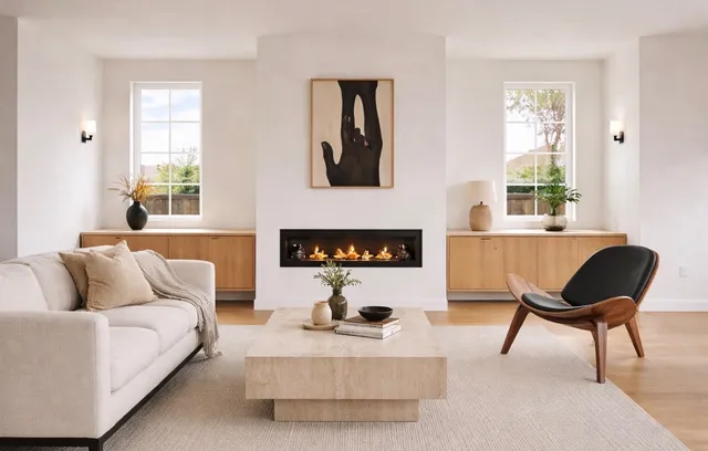 Living room with a linear fireplace, floating wood cabinets, and abstract art