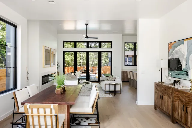 Open living and dining area with a wood table and sliding glass doors to the patio