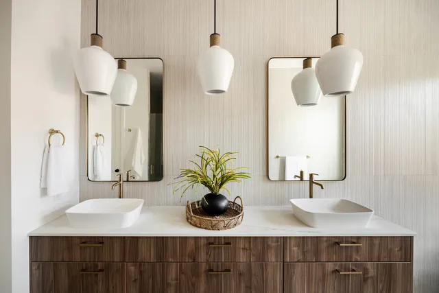 Bathroom with a double vanity, pendant lighting, and vessel sinks